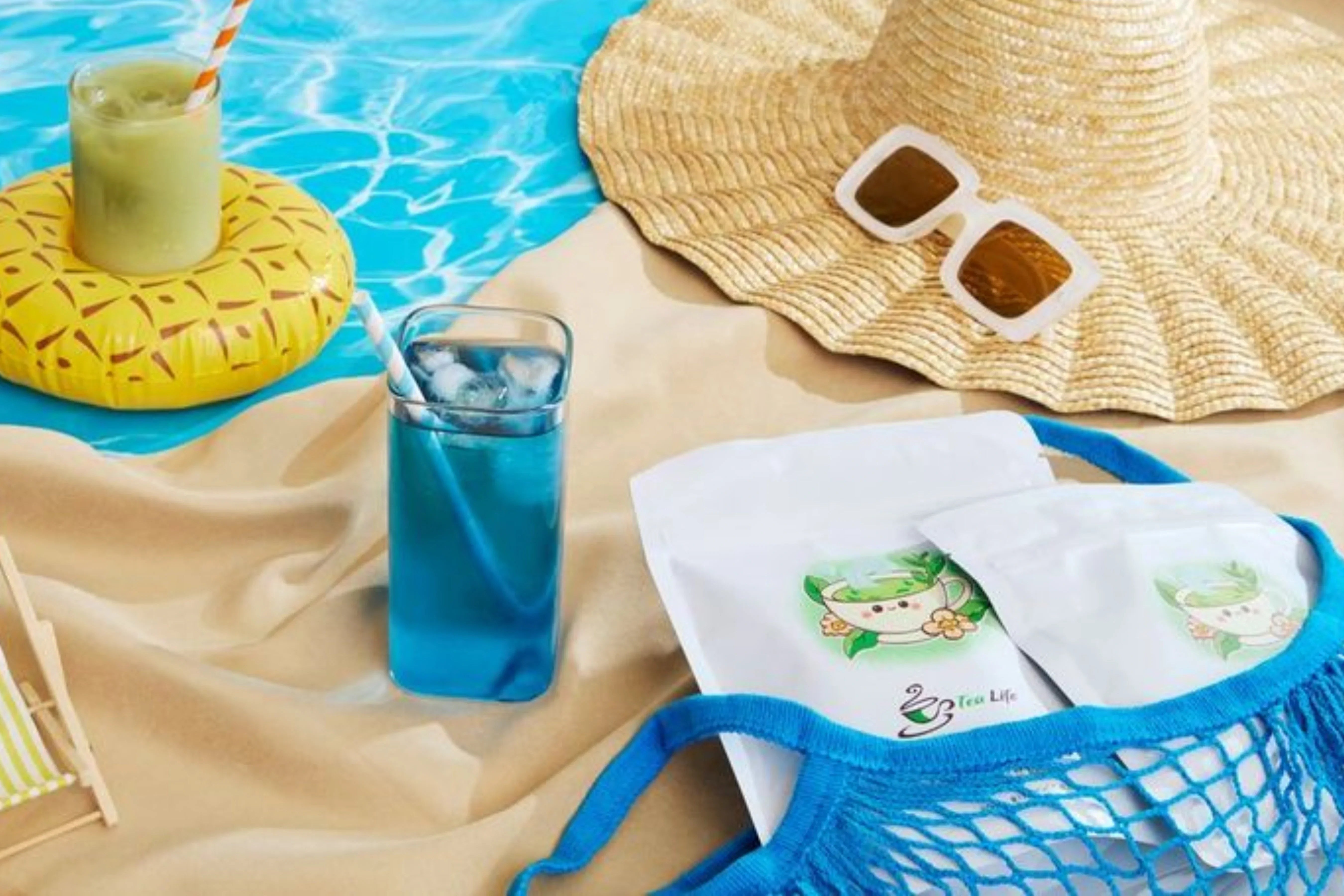 Summer hydration hero image with blue butterfly pea flower tea, sun hat, sunglasses, and iced matcha